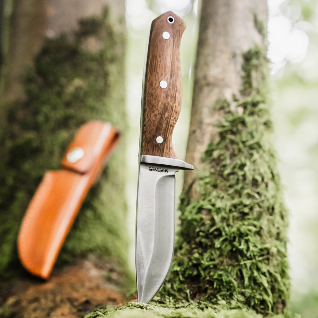 Ein Messer sitzt auf Moos im Wald.